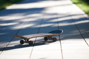 Old used skateboard on street photo