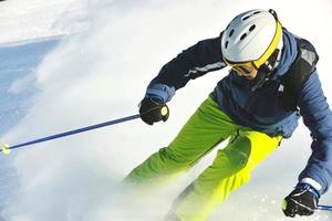 skiing on fresh snow at winter season at beautiful sunny day photo