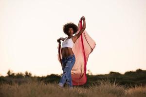 black girl dances outdoors in a meadow photo