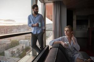 pareja joven disfrutando del café de la noche junto a la ventana foto