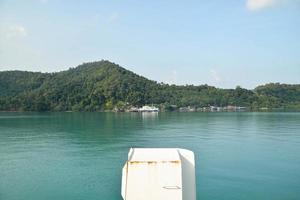 View of behind the stern of the ferry boat against the background of mountain. Snap shot on boat view. photo