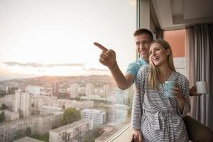 young couple enjoying evening coffee by the window photo