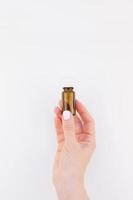 Woman hand with small glass bottle isolated photo