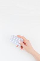 mano femenina con pastillas en blister foto