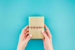 Woman hands holding golden diary photo