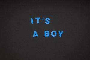 It's a boy writing on black paper background photo