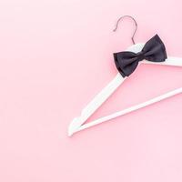 White hangers on pastel pink background photo