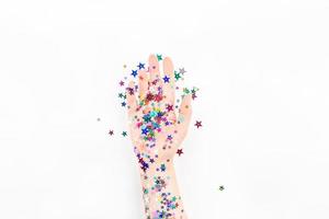 Woman hand with festive color star confetti photo