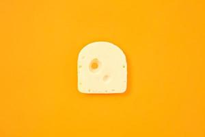 Piece of cheese on orange color background photo