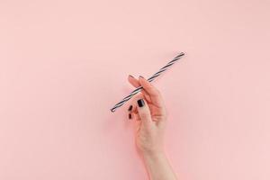 Woman hand with cocktail drinking straw photo