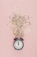 New Year concept. Alarm clock with golden confetti photo