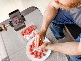Man preparing meatballs recording video smartphone photo