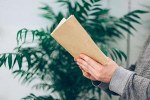 Young man reading open old paper book photo