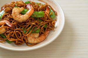 stir-fried yakisoba noodles with green peas and shrimps photo