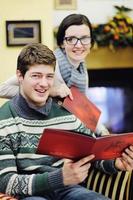 Young romantic couple relax on sofa in front of fireplace at home photo