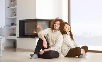 happy multiethnic couple  in front of fireplace photo