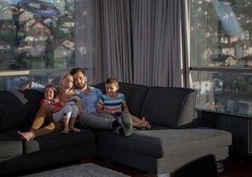 feliz pareja joven pasando tiempo con los niños en casa foto