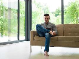 man on sofa using tablet computer photo