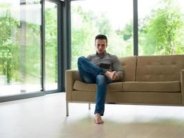 man on sofa using tablet computer photo