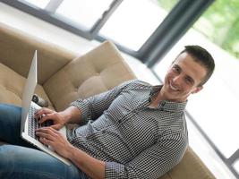 Man using laptop in living room photo