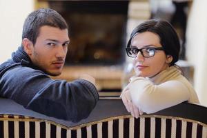 Young romantic couple sitting and relaxing in front of fireplace at home photo