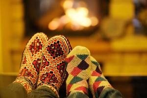 Young romantic couple sitting on sofa in front of fireplace at home photo
