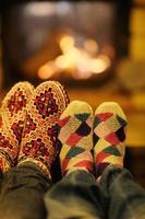 Young romantic couple sitting and relaxing in front of fireplace at home photo