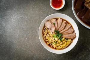 tallarines de huevo con pato guisado en sopa marrón foto