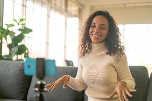 Latin woman influencer shooting video and talking with camera for blog photo