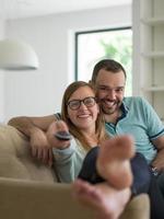 Young couple on the sofa watching television photo