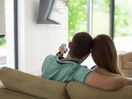 Young couple on the sofa watching television photo