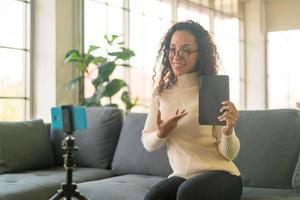 Latin woman influencer shooting video and talking with camera for blog photo