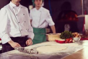 chef preparing dough for pizza photo