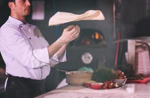 chef throwing up pizza dough photo