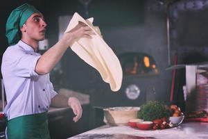 chef throwing up pizza dough photo