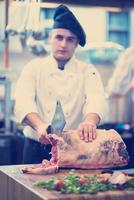 chef cutting big piece of beef photo