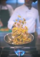 chef flipping vegetables in wok photo