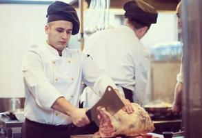 chef cutting big piece of beef photo