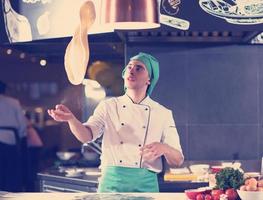 chef throwing up pizza dough photo