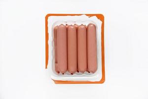 Juicy meat sausages in plastic packaging on a white background. Sausages in the group.Meat semi-finished product in a package. photo