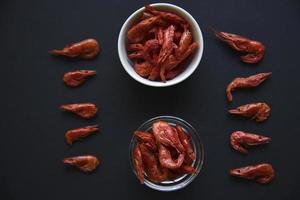 Red dried shrimp with pepper for beer on a black background. photo