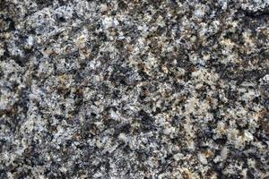 Granite gray stone background close-up. Granite stone patterns on the surface. photo