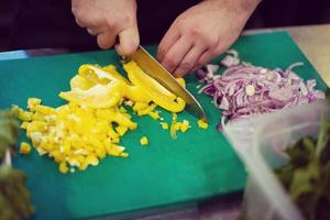 chef manos cortando verduras frescas y deliciosas foto