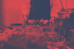 female Chef holding beef steak plate photo