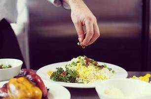 Chef hands serving vegetable risotto photo