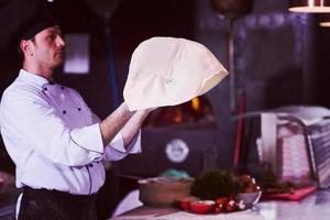 chef throwing up pizza dough photo