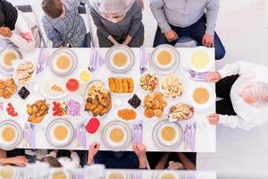 vista superior de la familia musulmana multiétnica moderna esperando el comienzo de la cena iftar foto