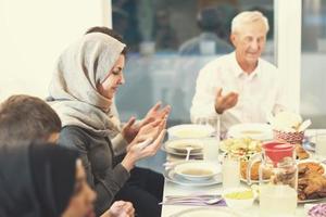 modern multiethnic muslim family praying before having iftar dinner photo