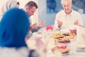 modern multiethnic muslim family praying before having iftar dinner photo