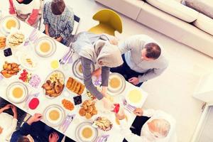 vista superior de la familia musulmana multiétnica moderna esperando el comienzo de la cena iftar foto